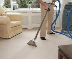 Carpet cleaning professional removing dirt and stains with a hot-water extraction tool in a home, Bellevue, WA.